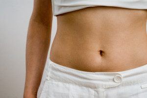 Woman in white showing her tummy