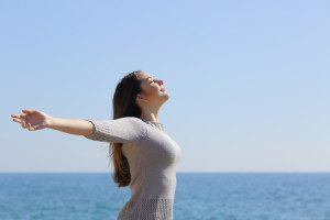 Woman with arms open to the sunlight