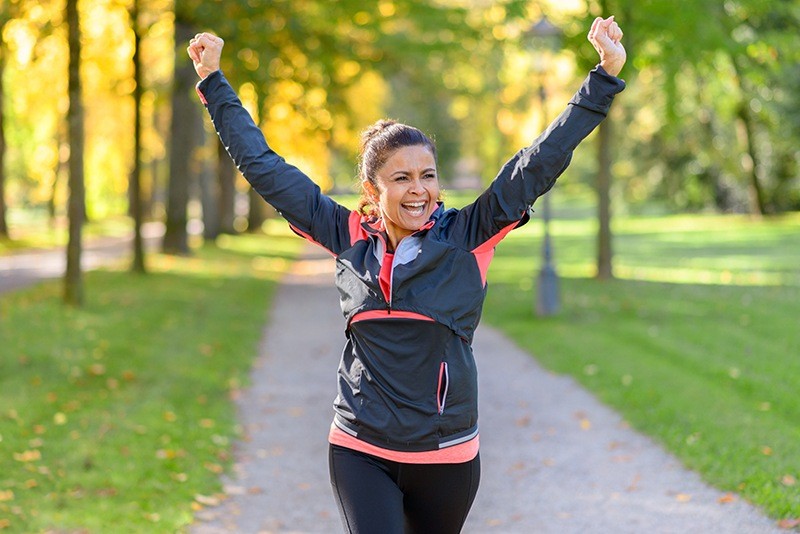 Woman running with her hands up in victory