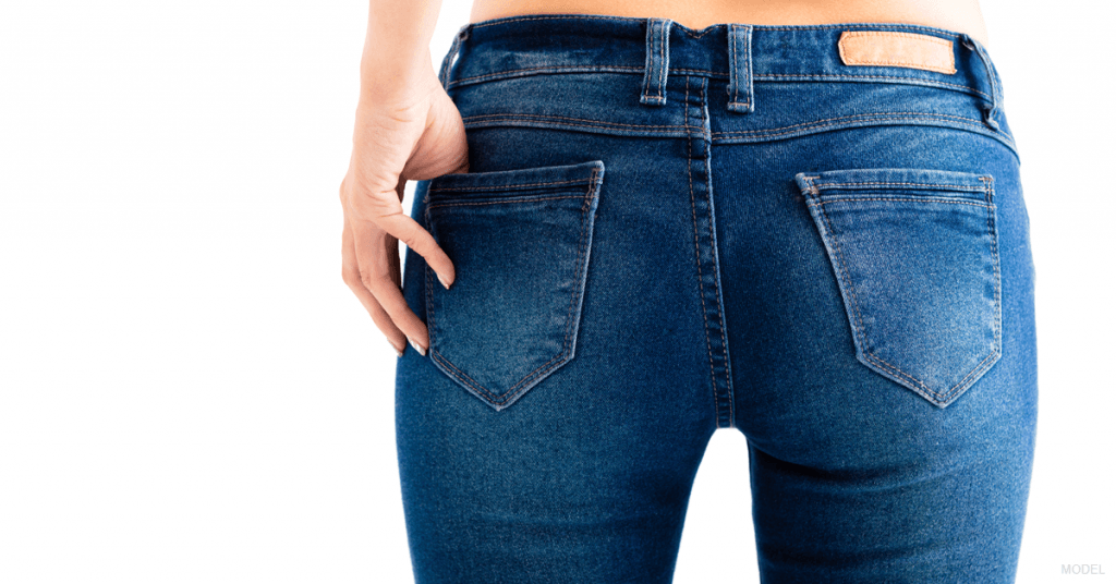 A woman standing in jeans.