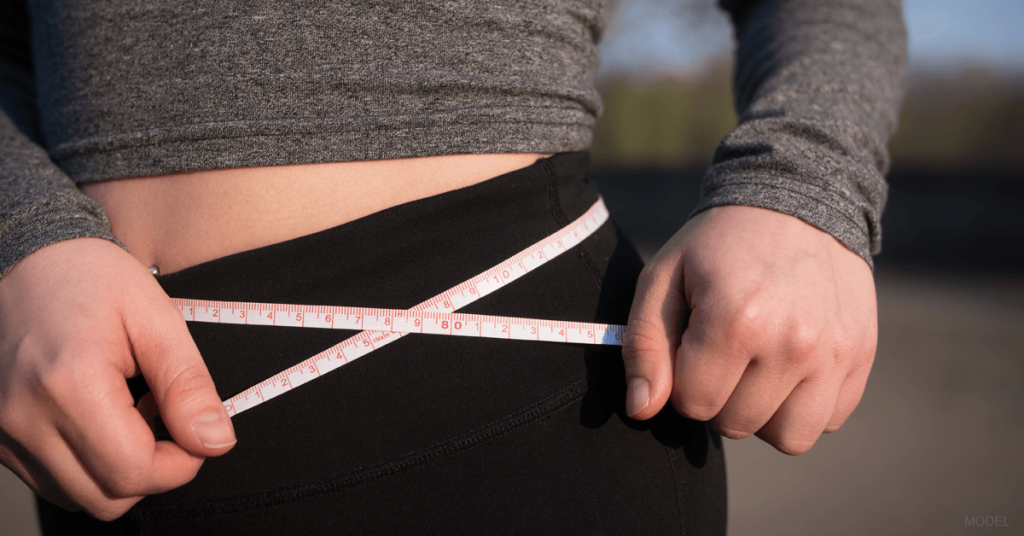 A mom measures her narrower waistline after undergoing several EmScuplt treatments.