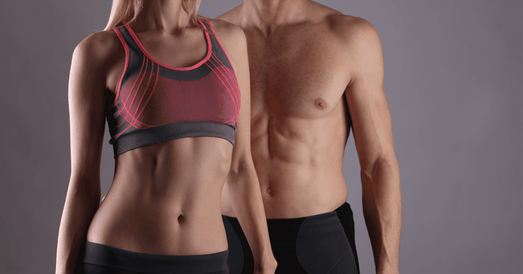 A man and woman stand next to each other after receiving nonsurgical body sculpting treatments.