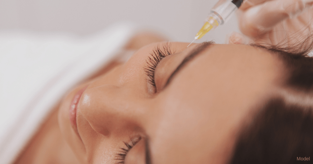 woman receiving a dermal filler injection by the eye (model)