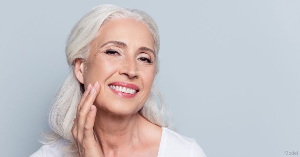 An older woman touching her face (model)