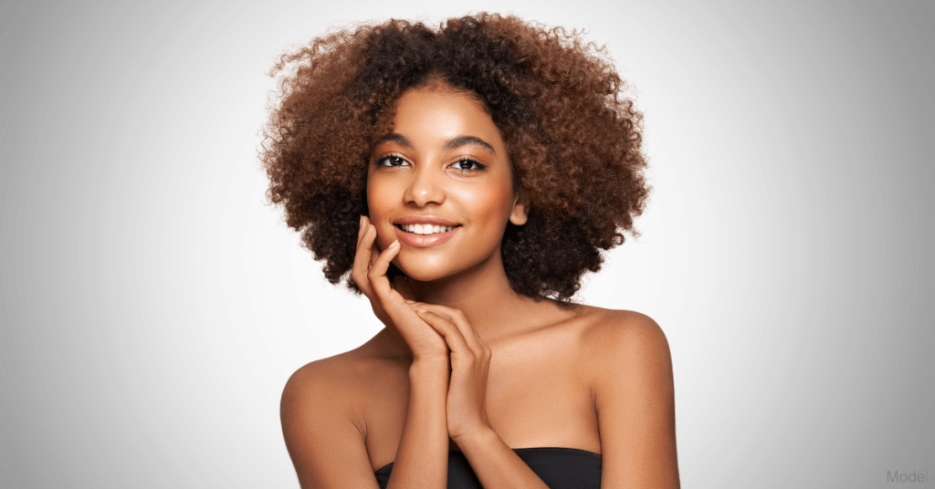 A woman with her hand on her cheek, smiling (model)