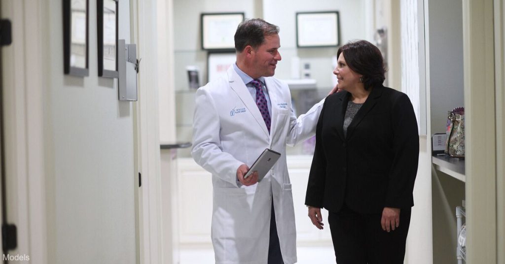 Dr. Weiler walking with a patient (model)