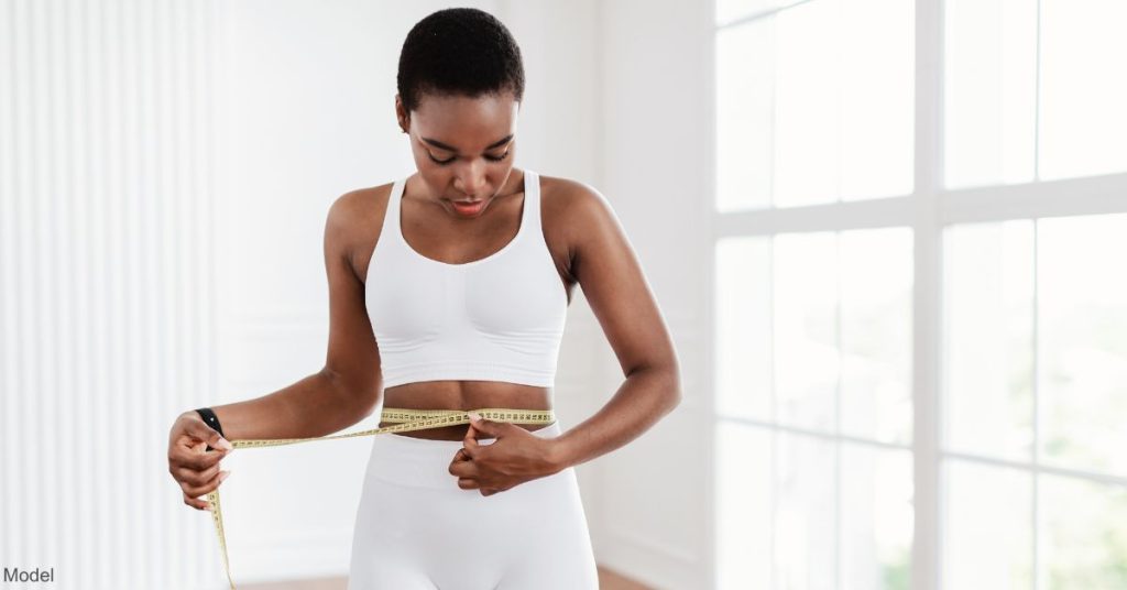 A woman measuring her waist (model)